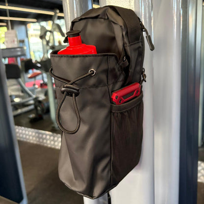 Black Smart Magnetic Gym Bag attached to a metal Work out Machine in a gym setting